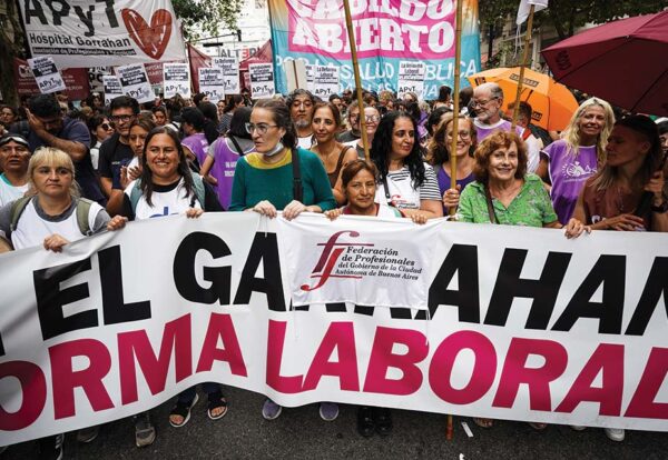 En el marco del Paro convocado por la CGT, la Federación de Profesionales del GCABA junto a otras organizaciones de salud que participan del Cabildo abierto, marchan contra la Reforma laboral 19/02/2026. En la foto: Andrea Ramírez, Rosa Favre y Natalia Castrogiovanni, integrantes del Consejo Ejecutivo,marchando junto a otras/os compañeros/as de la Federación de Profesionales del GCABA. Créditos: Antú Divito Trejo para FPSalud.
